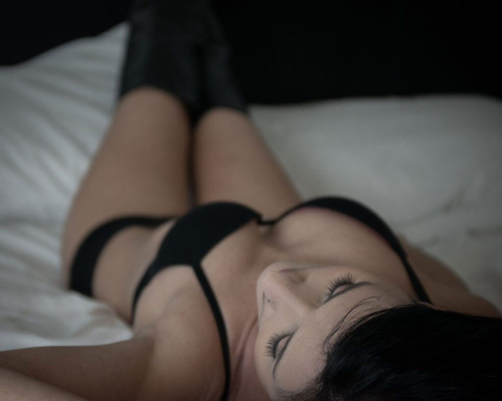 brunette woman in black lingerie on bed in elegant beauty and boudoir portraits taken by Krista Nutter Photography artist vision