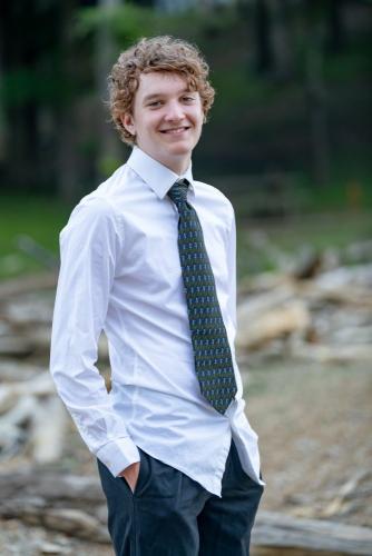 KristaNutterPhotography8504973 senior boy standing in shirt and tie on rocky lakeshore beach destination portrait sessions