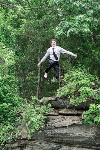 KristaNutterPhotography8505019 senior boy in shirt and tie jumping off rocky cliff into lake destination portrait sessions