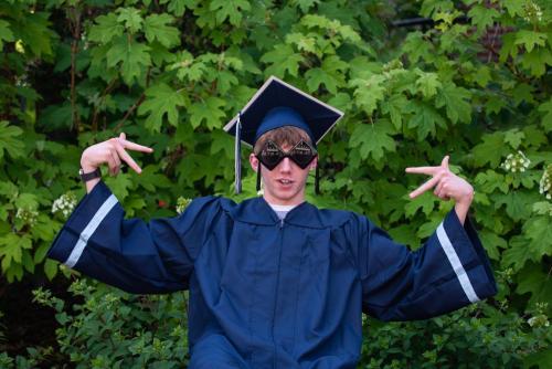 senior boy in blue graduation cap and gown and sunglasses senior portrait by Krista Nutter Photography Cincinnati