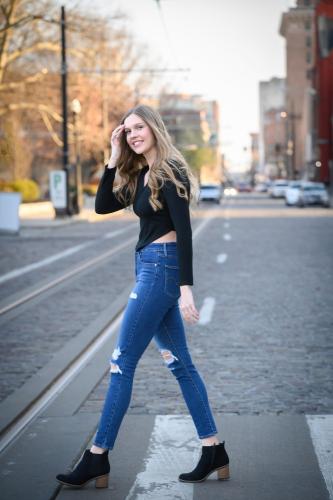 senior girl in black shirt and jeans crossing elm street in downtown Cincinnati senior portrait by Krista Nutter Photography Cincinnati
