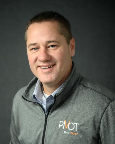 KristaNutterPhotography_9551-2 man in gray Pivot Realty polo shirt on gray backdrop headshots and personal branding portraits by Krista Nutter Photography Cincinnati